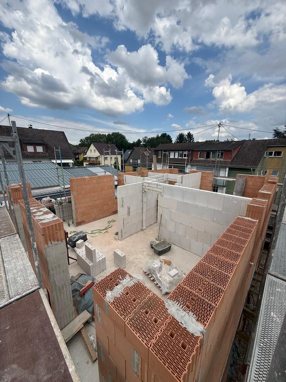 Blick von oben auf das aufgehende Mauerwerk eines Neubaus